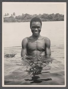 Men standing in waist-deep water, with fishing spears - Digital Collections  - Northwestern University Libraries